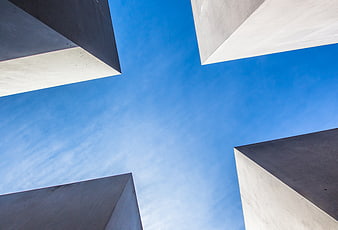 Low angle view of modern concrete buildings against blue sky