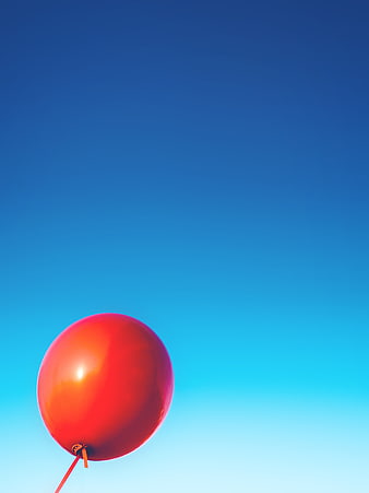 Red Balloon Floating Against Blue Sky Gradient Background