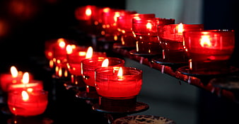 Rows of red votive candles burning in a church