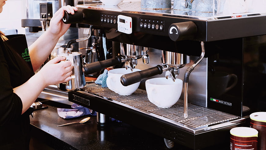 Barista making espresso with professional coffee machine
