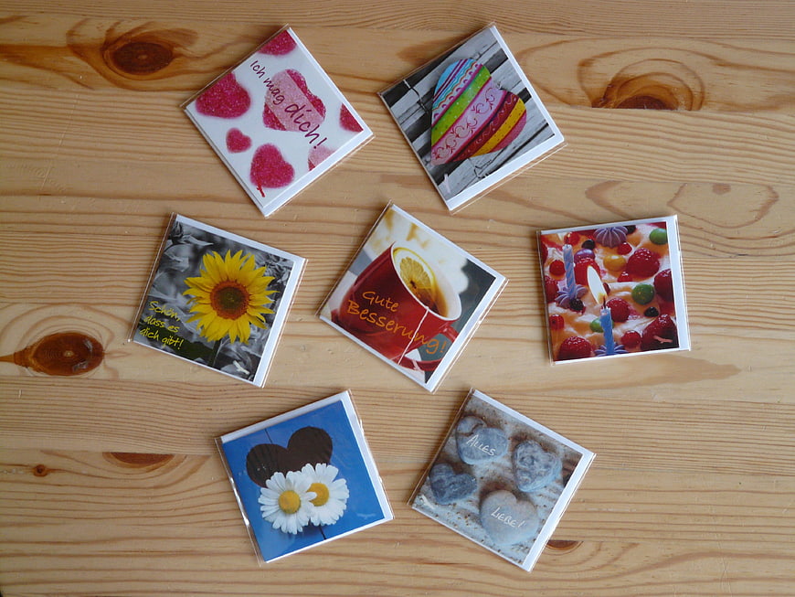 Assorted greeting cards with German text on wooden table