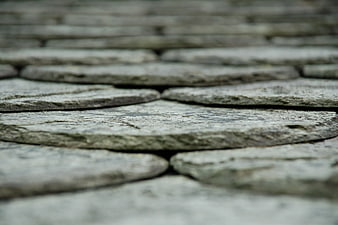 Close-up of weathered gray cobblestone pavement texture