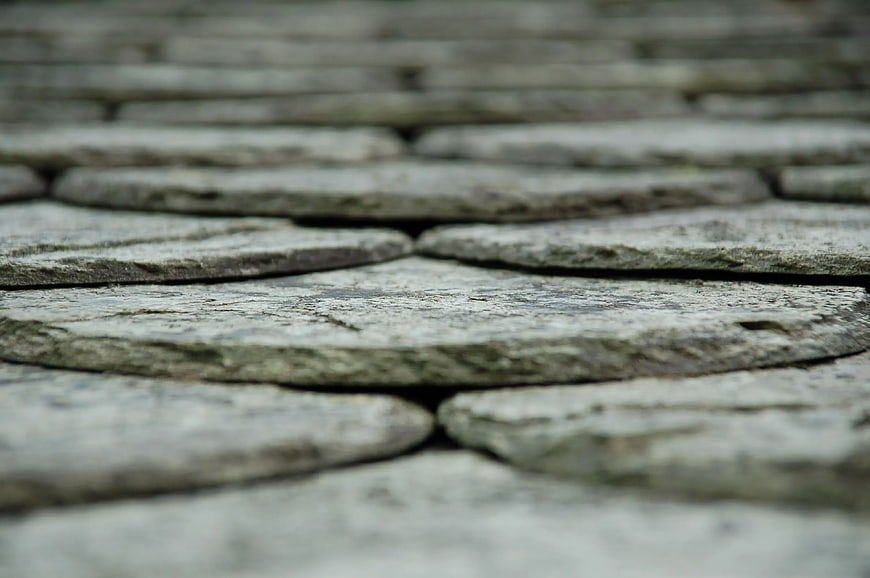 Close-up of weathered gray cobblestone pavement texture