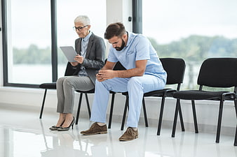Male nurse and woman waiting in clinic