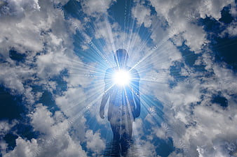 Silhouette of person with glowing light in clouds