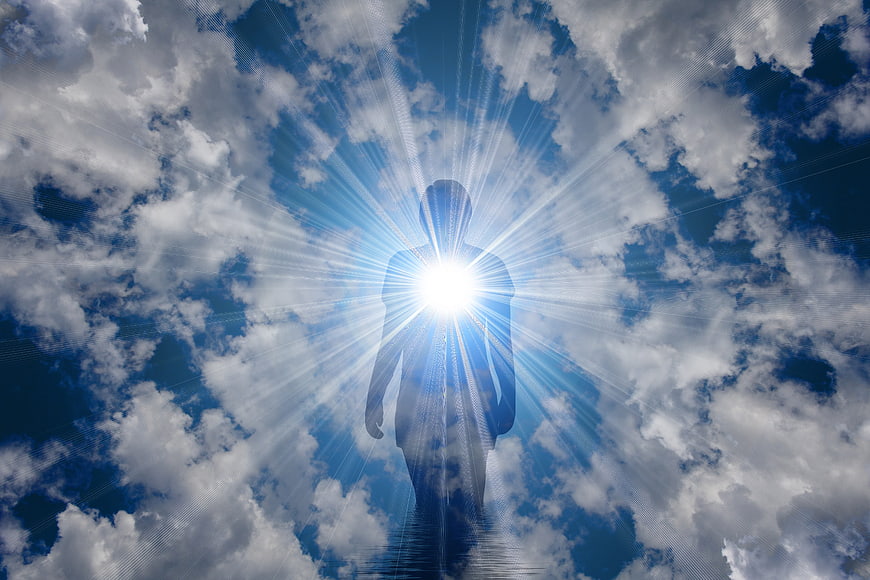 Silhouette of person with glowing light in clouds