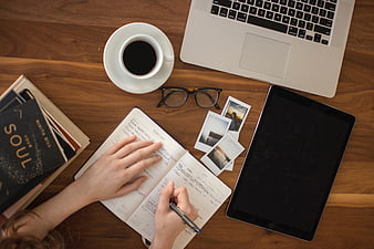 Overhead view of workspace with laptop, coffee, and planner