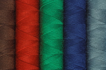 Close-up of colorful sewing threads in brown, red, green, blue, and gray
