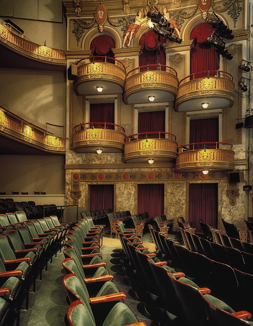 Interior of ornate historic theater with green velvet seats