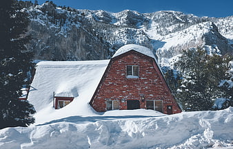 Red Brick Cabin Buried in Snow with Mountain Backdrop