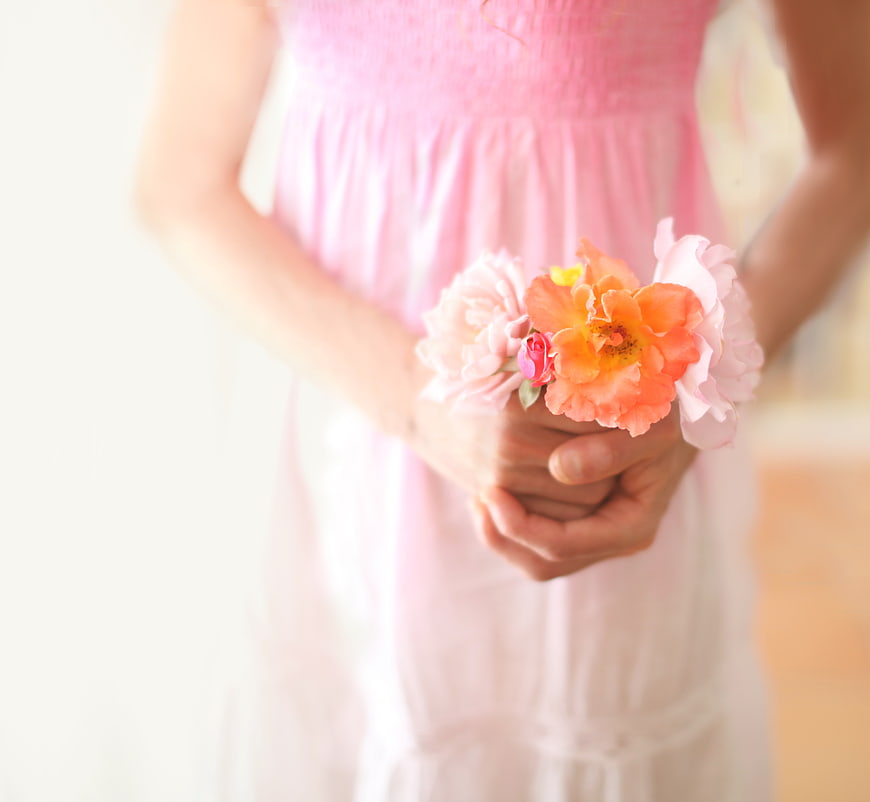 Woman in Pink Dress Holding Peach and Pink Flowers