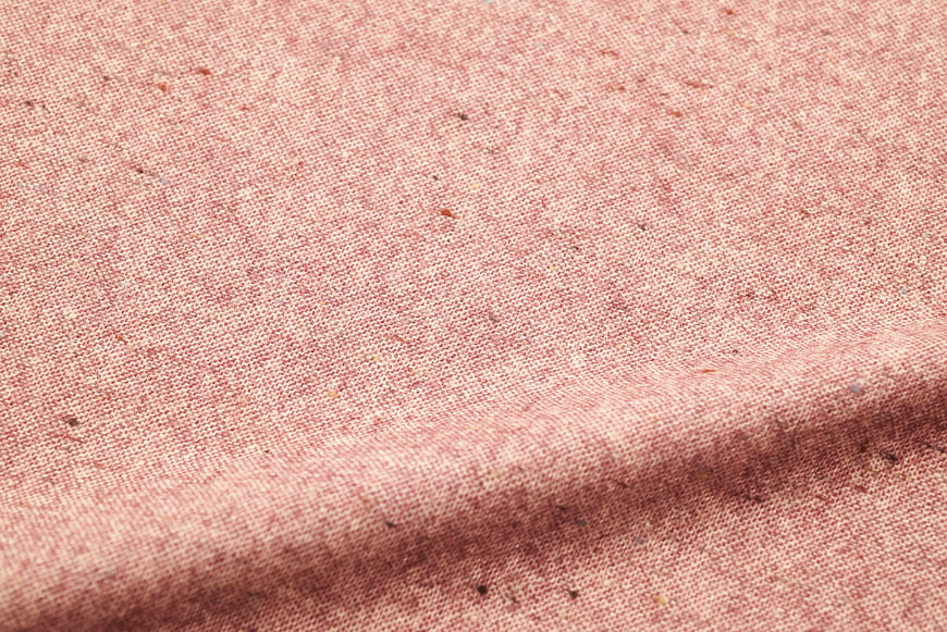 Close-up of textured pink fabric weave with natural fibers