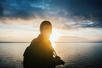 Silhouette of Photographer with Camera at Sunset by the Sea