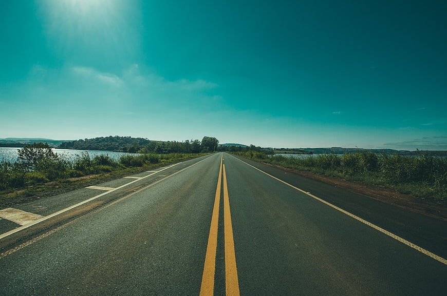 Empty Highway Road with Yellow Lines and Lake View