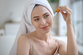 Woman applying serum with dropper for skincare routine