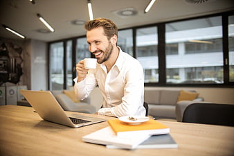 Happy Bearded Businessman Drinking Coffee in Modern Office