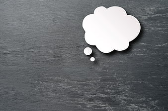 White paper thought bubble on dark slate background