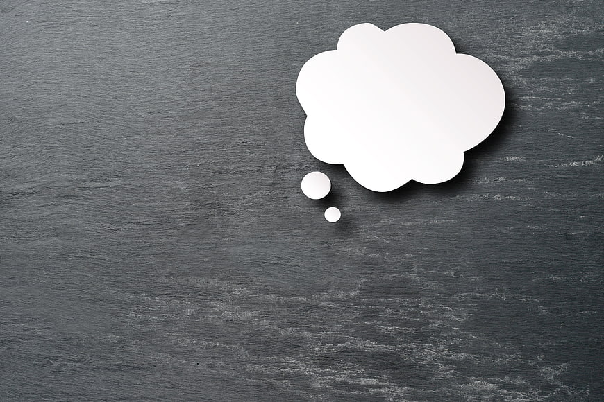White paper thought bubble on dark slate background