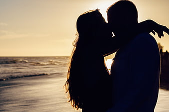 Silhouette of Romantic Couple Kissing on Beach at Sunset