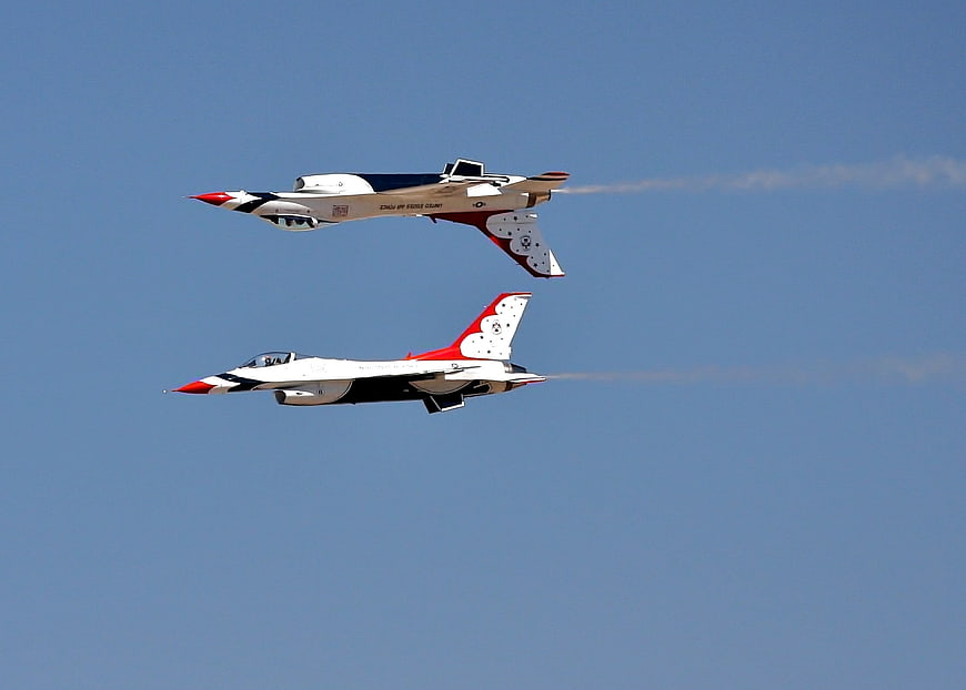 Two Military Fighter Jets Flying In Formation Against Blue Sky