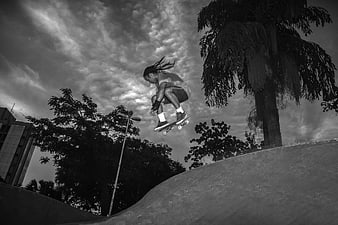 Black and white skateboarder jumping in skate park