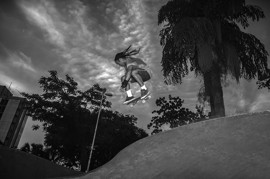 Black and white skateboarder jumping in skate park