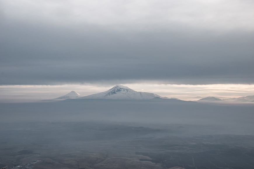 Snow-capped mountains rising above a sea of clouds