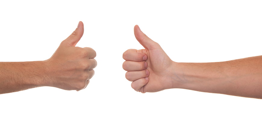 Two hands giving thumbs up gesture on white background