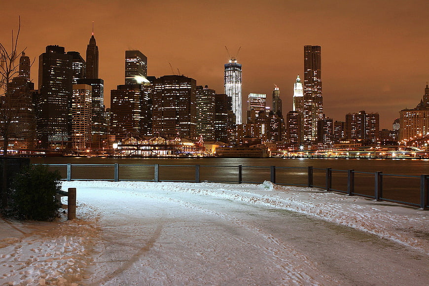 Manhattan Skyline at Night with Snowy Riverside Promenade
