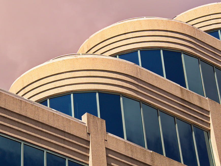 Modern curved office building architecture with blue glass windows