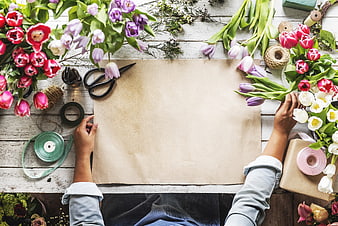 Florist wrapping flowers with kraft paper and ribbons