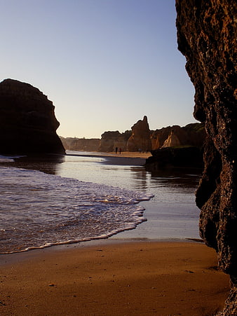 Golden hour view of rocky coastline with ocean waves