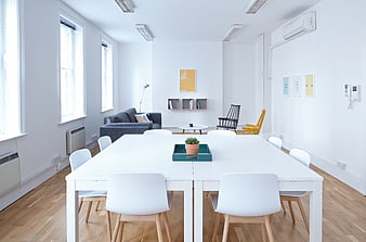 Bright modern office interior with white table and chairs
