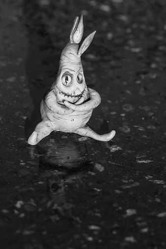 Black and white photo of a quirky clay rabbit sculpture