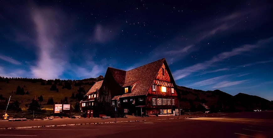 Illuminated Mountain Lodge Under Starry Night Sky