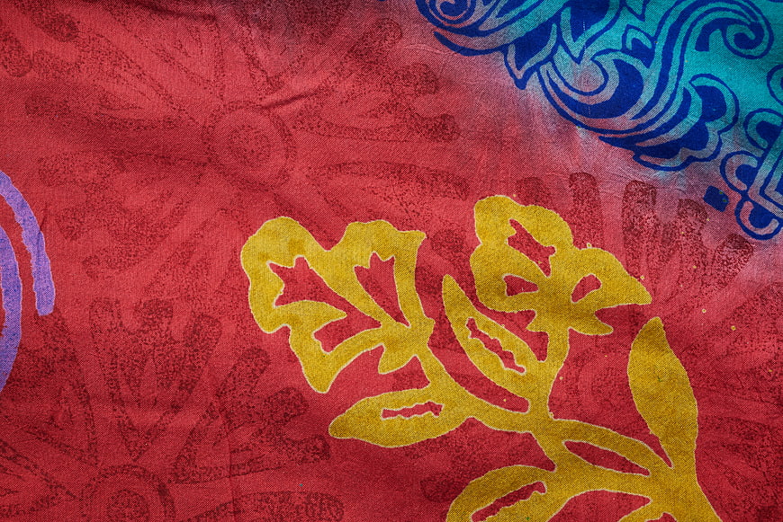 Vibrant Red Textile with Yellow and Blue Floral Patterns