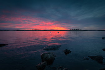 Dramatic Pink and Blue Sunset Over Calm Water with Rocks