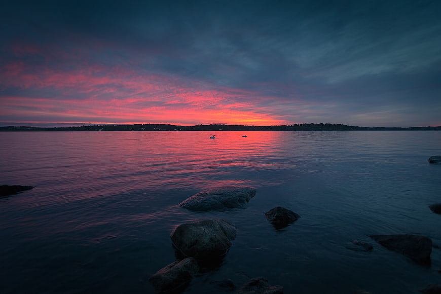 Dramatic Pink and Blue Sunset Over Calm Water with Rocks