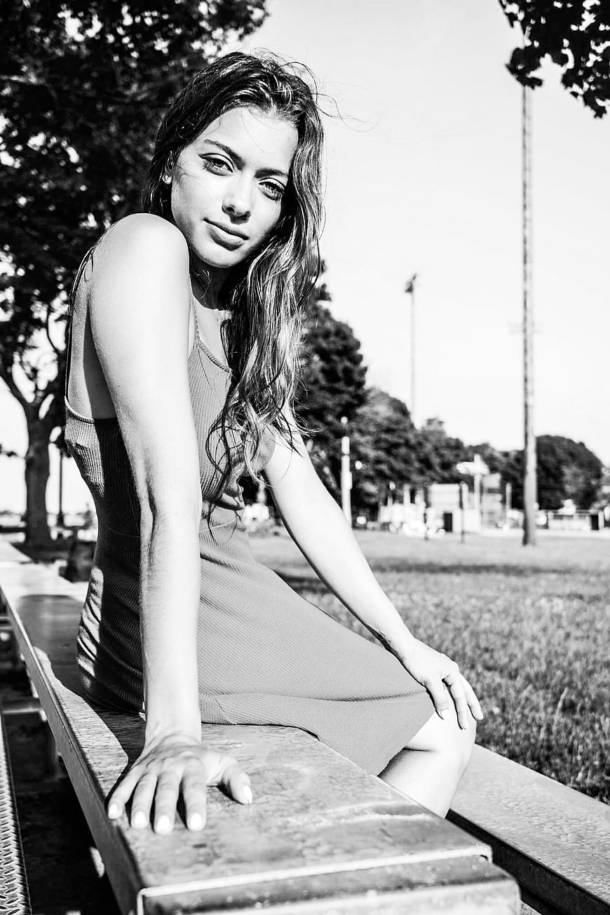 Black and white portrait of woman sitting on park bench