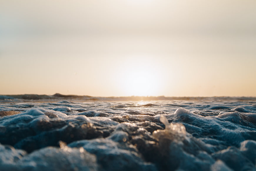 Close-up of ocean waves at sunrise with golden light