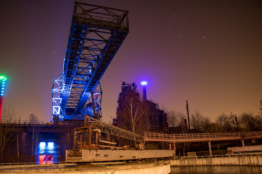Illuminated industrial crane and factory at night in Duisburg
