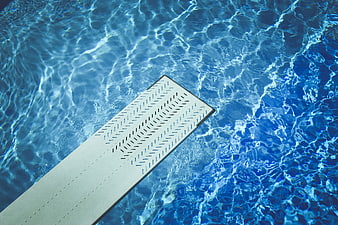 Top View of Diving Board Over Blue Pool Water