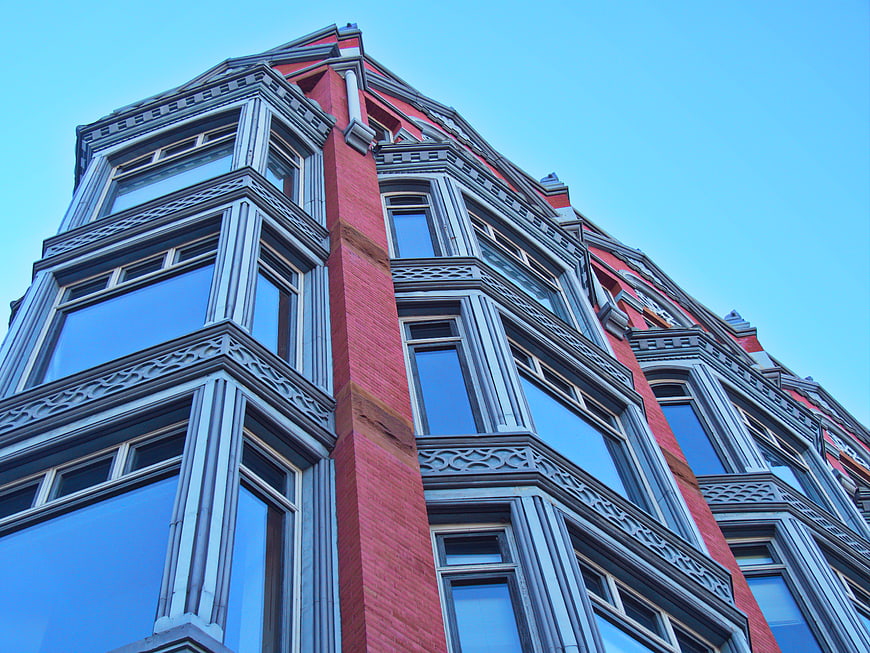 Low angle view of red brick building facade with blue sky