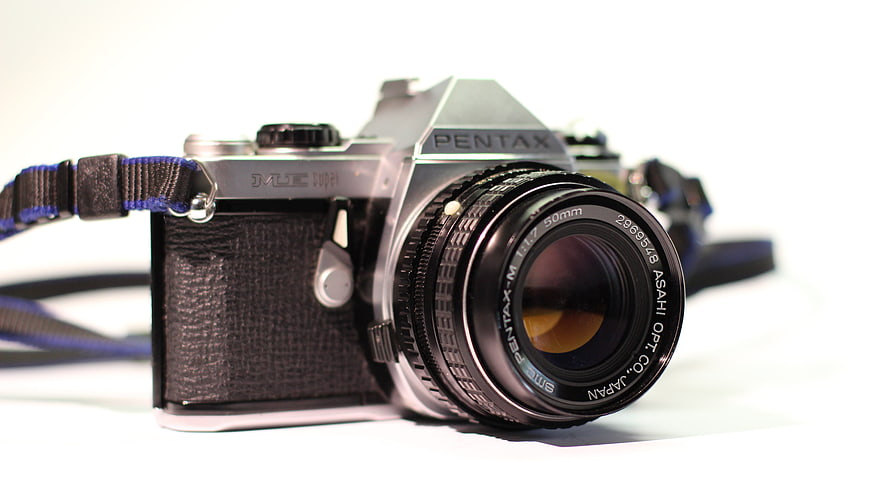 Vintage Pentax SLR Camera With 50mm Lens On White Background