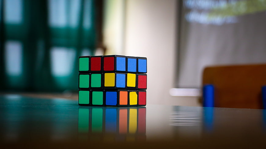 Unscrambled Rubik's Cube on Glossy Table