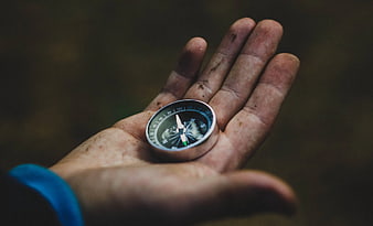 Dirty Hand Holding Compass in Forest