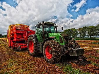 Green Fendt Tractor Pulling Red Harvester in Field