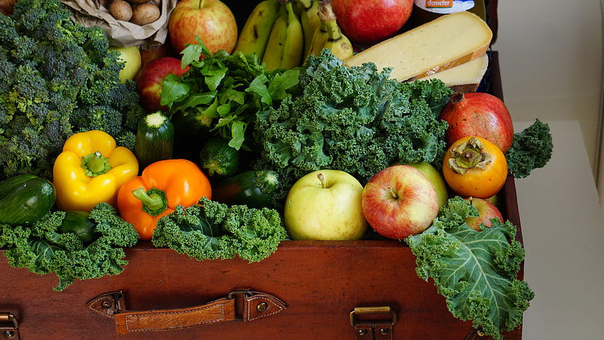 Vintage suitcase overflowing with fresh fruits and vegetables