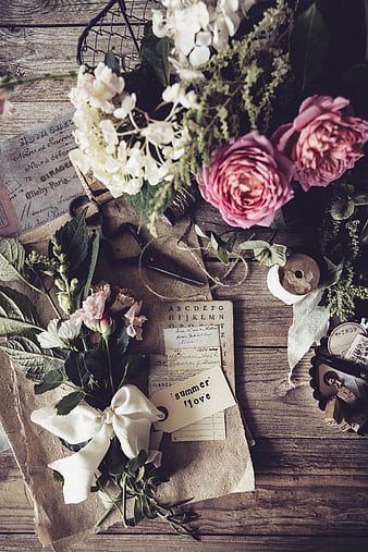 Vintage floral flat lay with rustic paper and wooden background