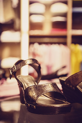 Close-up of metallic gold wedge sandals in boutique